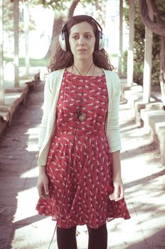 vintage hipster eastern woman with headphones in the park