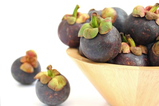 Mangosteen in a wooden bowl isolated on white background