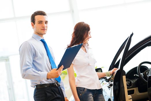 car salesman declares a young girl advantages of the new car