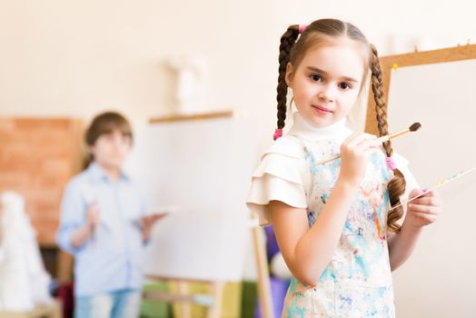 portrait of a girl standing next to his easel, a drawing lesson