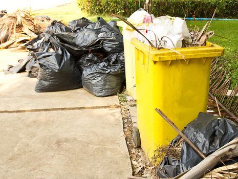 Garbage in the yellow trash on the garden.