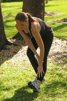 young woman stretching in summer outside after exercising
