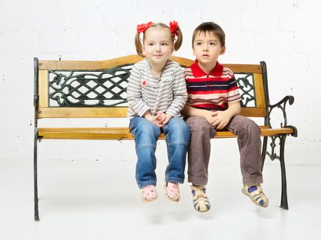 beautiful girl and boy sitting on bench