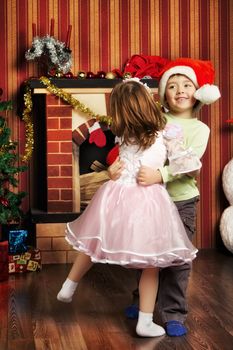 two beautiful child dancing near christmas tree