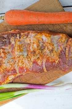 Raw pork ribs seasoned for baking on a wooden board