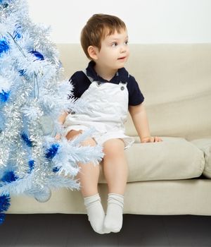 beautiful happy small kid decorate christmas tree