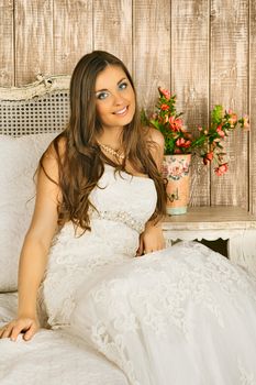 charming smiling bride sitting on a bed