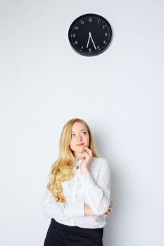 office girl watch on clock and waiting end of work day