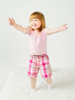 beautiful little girl playing and smilng on bed