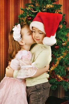 two beautiful child stand near christmas tree