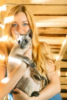 beautiful girl with cat on hayloft at summer day