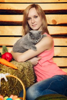 beautiful girl with cat on hayloft at summer day