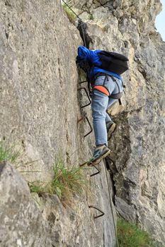 female climber with white helmet on Sass de Rocia via ferrata, italian Dolomites