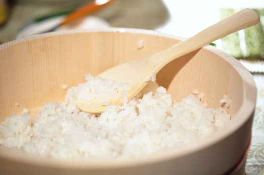 Cooking sushi. Mixing rice in wooden plate. Beautiful macro with shallow dof.