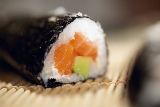 Susshi roll with salmon and avocado. Beautiful macro with shallow dof.