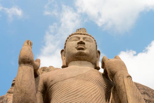 Avukana standing Buddha statue, Sri Lanka under blue sky. 40 feet (12 m) high, has been carved out of a large granite rock in the 5th century.