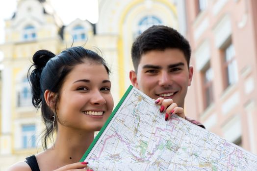 Trendy young couple in town with touristic map