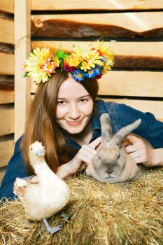 beautiful girl with rabbit on hayloft at summer day