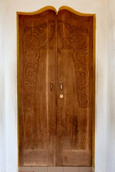 Old grunge wooden door with carving in arch