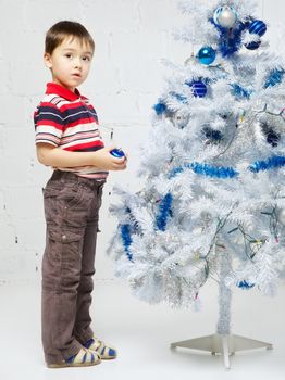 beautiful happy small boy decorate christmas tree