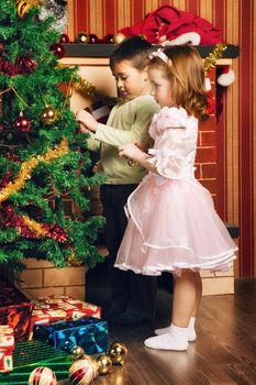 beautiful boy and girl decorate christmas tree