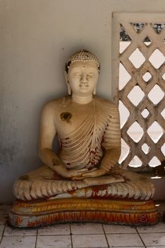 Small grunge Buddha statue in a niche, Avukana, Sri Lanka