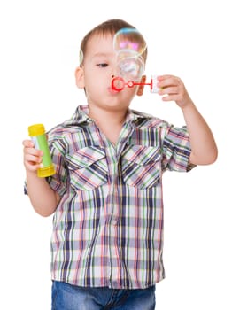 Portrait of funny little boy blowing soap bubbles isolated on ehite background