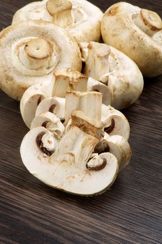 Heap of Big White Champignons Full Body and Slices on Dark Wood background