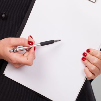 Pen on a blank paper in businesswoman hands with manicure