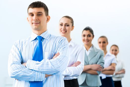 group of business people standing in a row, smiling and crossing his arms