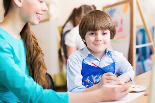 teacher deals with a boy, a drawing lesson