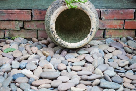 Garden earthen jar decorated on brown pebble