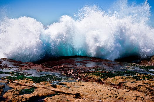 Large wave breaking against rocky coastal shoreline