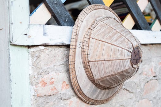 Old handmade hat hanging on vintage wall