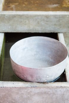 Single old stainless water bowl floating on water