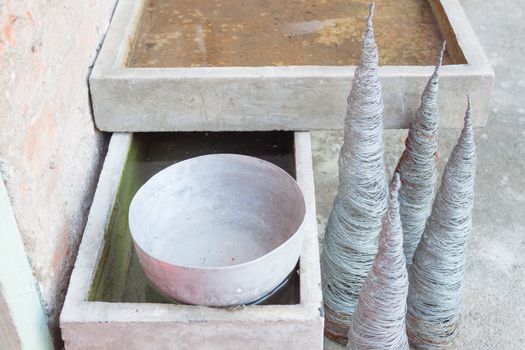 Single old stainless water bowl surrounded by water