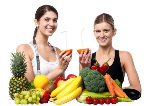 Young girls each holding juicy sliced orange