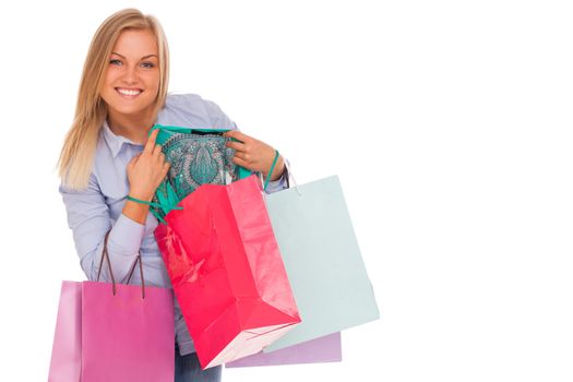 Young blond caucasian woman with shopping bags smiling over white background