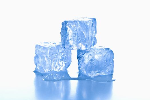 ice cubes shot on reflective white surface