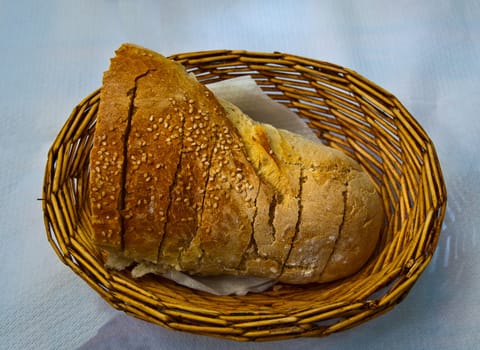 Bread with sesame seeds in a wicker basket.
