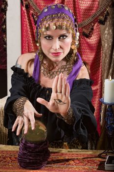 Mysterious female fortune teller showing an evil eye in palm