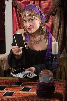 Pretty female gypsy fortune teller with tarot cards