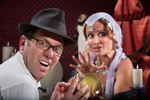 Unlucky sneering man with fortune teller and crystal ball 