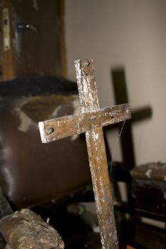 an old decaying wooden cross with shadows in abandoned room