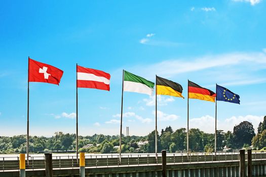 Flags of Germany, Switzerland, Austria and Europe in a row at a pier at Lake Constance