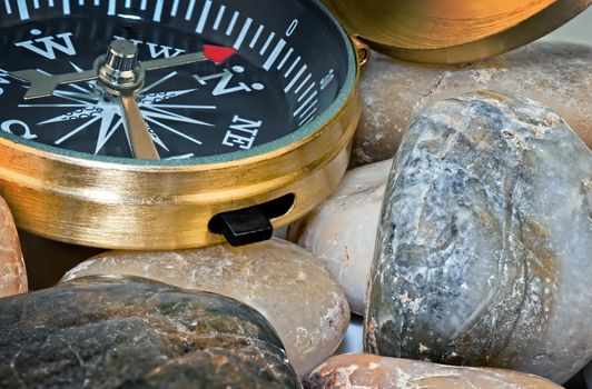 Navigation compass on stone pebbles