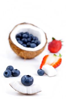 healthy fresh fruits - strawberry, blueberry and coconut isolated on white background