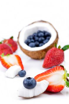 healthy fresh fruits - strawberry, blueberry and coconut isolated on white background