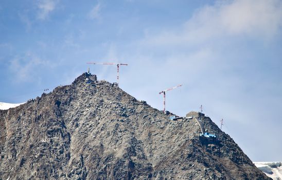 Cranes and building equipment on top of a mountain for high altitude construction