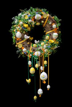 Colorful and festive Easter wreath with decorated eggs isolated on black